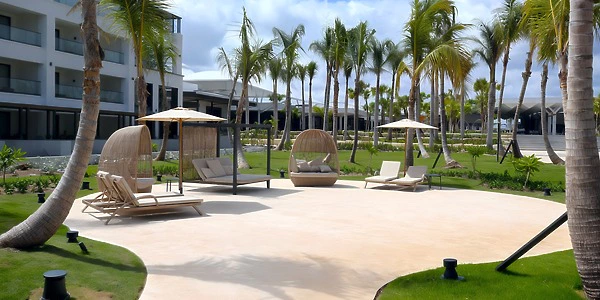 Garden Oasis venue with palm trees and lounge seating at Secrets Tides Punta Cana