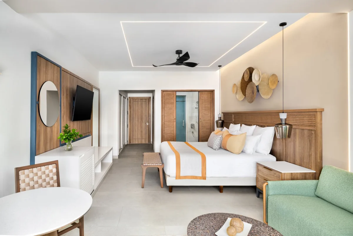 Junior Suite Garden View with king bed, wood accents, and modern seating area at Secrets Tides Punta Cana resort.