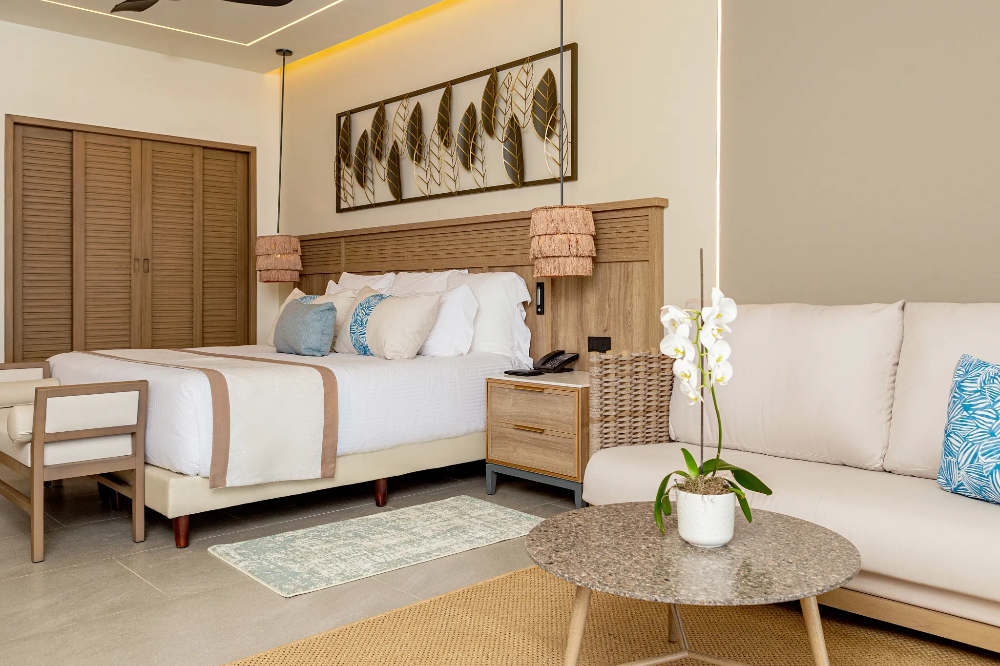 Preferred Club Junior Suite Swim Out king bed with sofa and tropical décor at Secrets Tides Punta Cana.