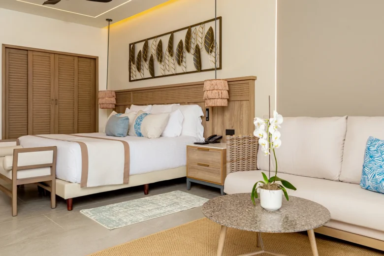 Preferred Club Junior Suite Tropical View with king bed and cozy seating area at Secrets Tides Punta Cana.